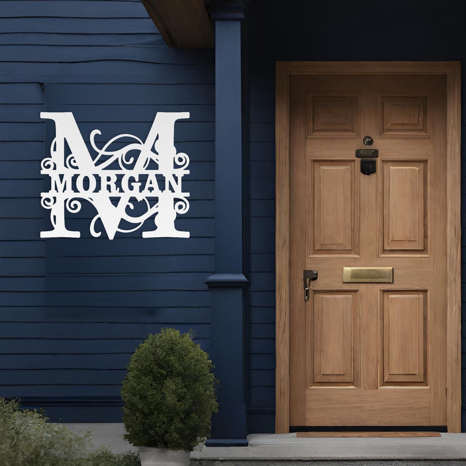 White split monogram custom metal sign hanging next to a front door.
